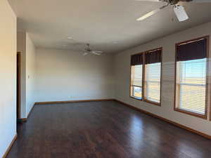 Spare room featuring a ceiling fan, dark wood-type flooring, and a textured ceiling