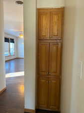 Corridor featuring baseboards and dark wood finished floors