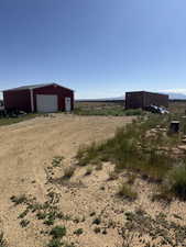 View of yard with an outdoor structure, driveway, and a garage