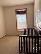 Unfurnished bedroom with light carpet and baseboards