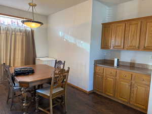 Dining room with baseboards and dark wood-style flooring