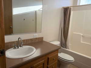 Full bathroom featuring shower / bath combination with curtain and vanity