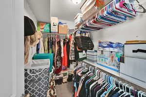Walk in closet featuring dark colored carpet