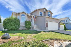 View of front facade featuring driveway, stucco siding, a garage, and brick siding