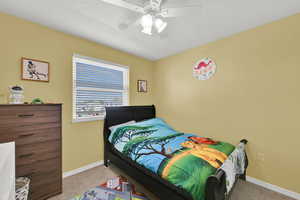 Bedroom with light carpet, a textured ceiling, and a ceiling fan