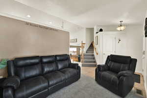 Living room with lofted ceiling, tile patterned flooring, stairway, a textured ceiling, and recessed lighting