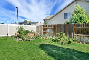 Fenced backyard featuring a garden