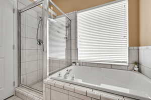 Full bath with a shower stall and a garden tub