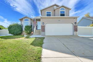 Traditional-style house with brick siding, driveway, a garage, and stucco siding