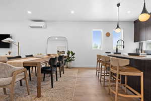 Dining area with healthy amount of natural light, recessed lighting, light wood-type flooring, and a wall unit AC