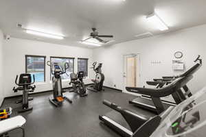 Exercise room featuring a ceiling fan and baseboards