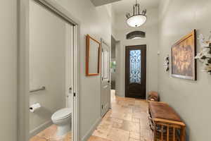 Entryway featuring stone tile flooring and a high ceiling