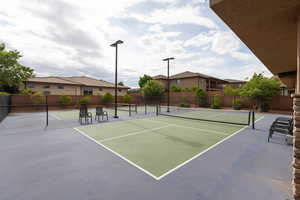 View of tennis court with a residential view