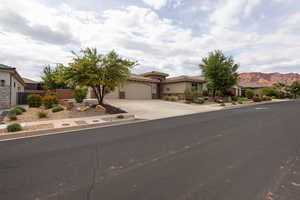 Mediterranean / spanish-style house with concrete driveway, stucco siding, stone siding, an attached garage, and a tile roof