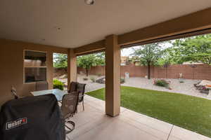 Fenced backyard featuring a patio, a grill, and outdoor dining space