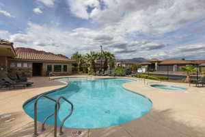 Community pool featuring a patio area, a community hot tub, and a residential view