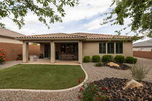 Rear view of property with stucco siding, a patio, and a tiled roof