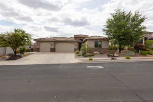 Mediterranean / spanish home with stone siding, driveway, a garage, stucco siding, and a tile roof