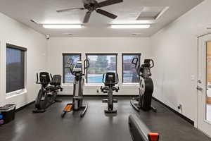 Workout room with a ceiling fan and baseboards