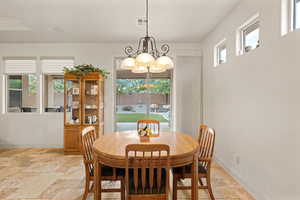 Dining space featuring stone tile floors and a chandelier