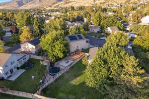 Aerial view of property and surrounding area featuring nearby suburban area and a mountainous background