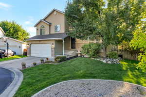 View of front of home featuring stucco siding, a garage, driveway, brick siding, and roof with shingles