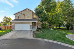 Traditional-style home featuring a garage, concrete driveway, stucco siding, and brick siding