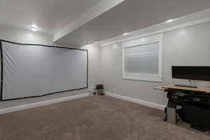 Carpeted cinema room with baseboards