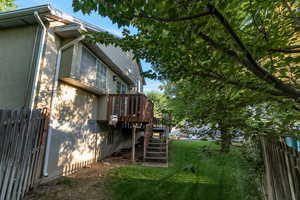 View of property exterior with stairs, a wooden deck, and stucco siding