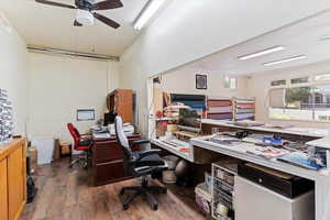 Office space with dark wood-type flooring and a ceiling fan