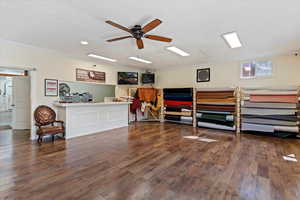 Interior space with dark wood-style floors, crown molding, and ceiling fan