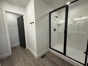 Full bathroom with a stall shower and wood finished floors