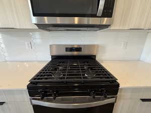 Kitchen view of appliances with stainless steel finishes, light stone countertops, and modern cabinets