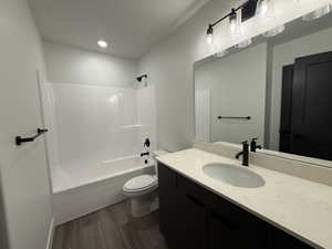 Full bathroom featuring shower / washtub combination, dark wood-style floors, and vanity