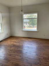 Unfurnished dining area with plenty of natural light, dark wood-style floors, and ornamental molding