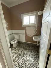 Half bathroom featuring toilet and baseboards