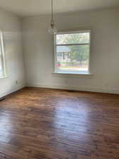 Unfurnished dining area featuring ornamental molding and dark wood-type flooring
