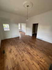Spare room featuring ornamental molding and wood-type flooring