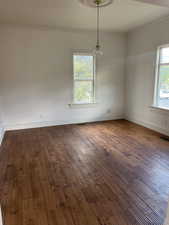Spare room featuring dark wood finished floors and crown molding