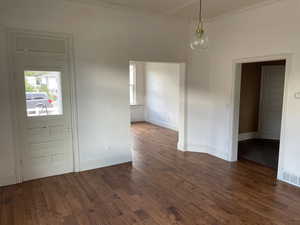 Entryway with dark wood-style flooring and ornamental molding