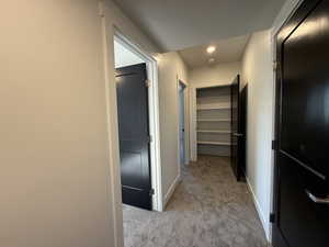 Hall featuring light colored carpet and recessed lighting