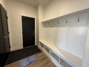 Mudroom featuring light wood finished floors and baseboards
