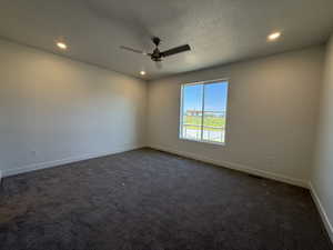 Unfurnished room featuring dark colored carpet, a textured ceiling, recessed lighting, and ceiling fan