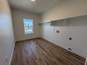 Laundry area featuring light wood-type flooring, hookup for an electric dryer, and washer hookup