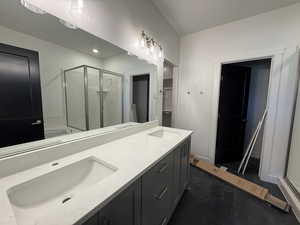 Bathroom featuring a shower stall, double vanity, and a bath