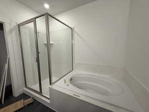 Bathroom with a bath and a marble finish shower