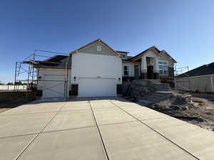 Craftsman-style home featuring board and batten siding, driveway, and a garage