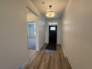 Entrance foyer with light wood-style floors and a textured ceiling
