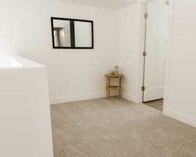 Unfurnished room with light colored carpet and baseboards