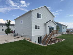 Back of property featuring a lawn and stairway